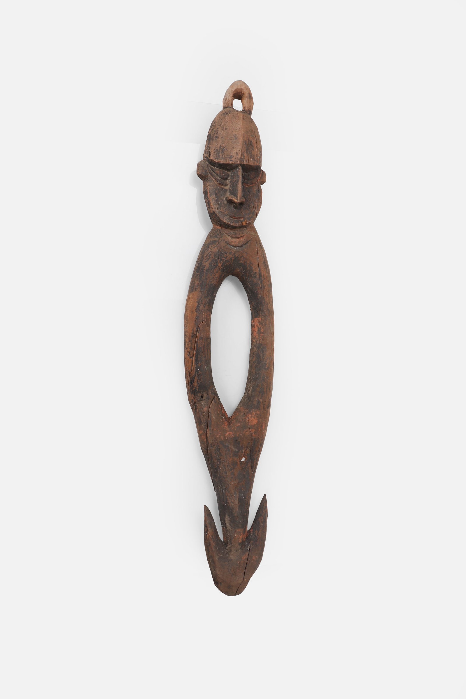 PNG Suspension Hook: Papua New Guinea, Sepik region, 20th century. Carved wood suspension hook with an elongated openwork body, terminating in a bifurcated lower hook and surmounted by a stylized ancestral head. The face