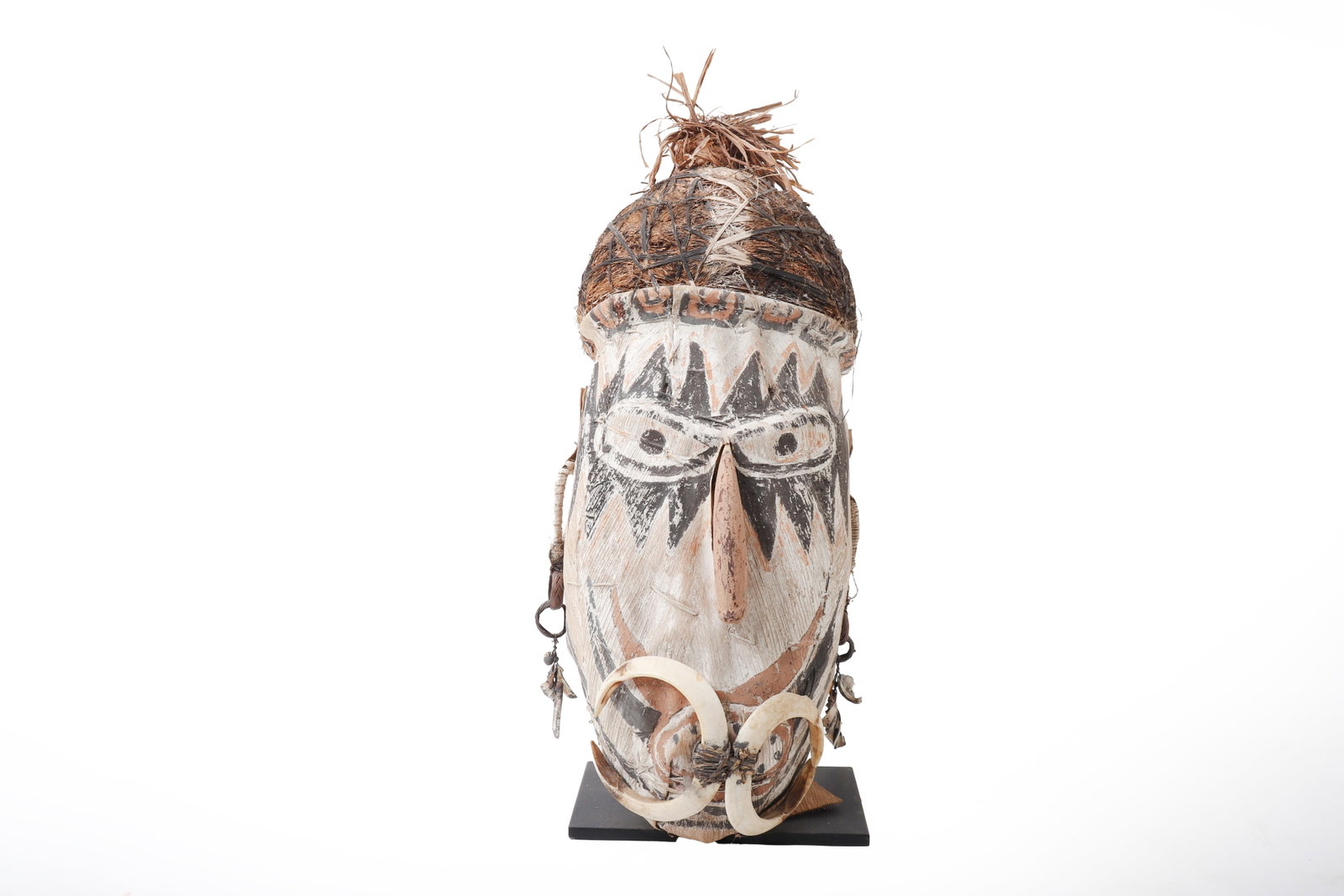Tago Mask, PNG: Papua New Guinea, likely East Sepik region, Tago mask. A large ceremonial mask of elongated oval form, constructed with a painted bark or fiber-covered face, natural fiber coiffure, and attached