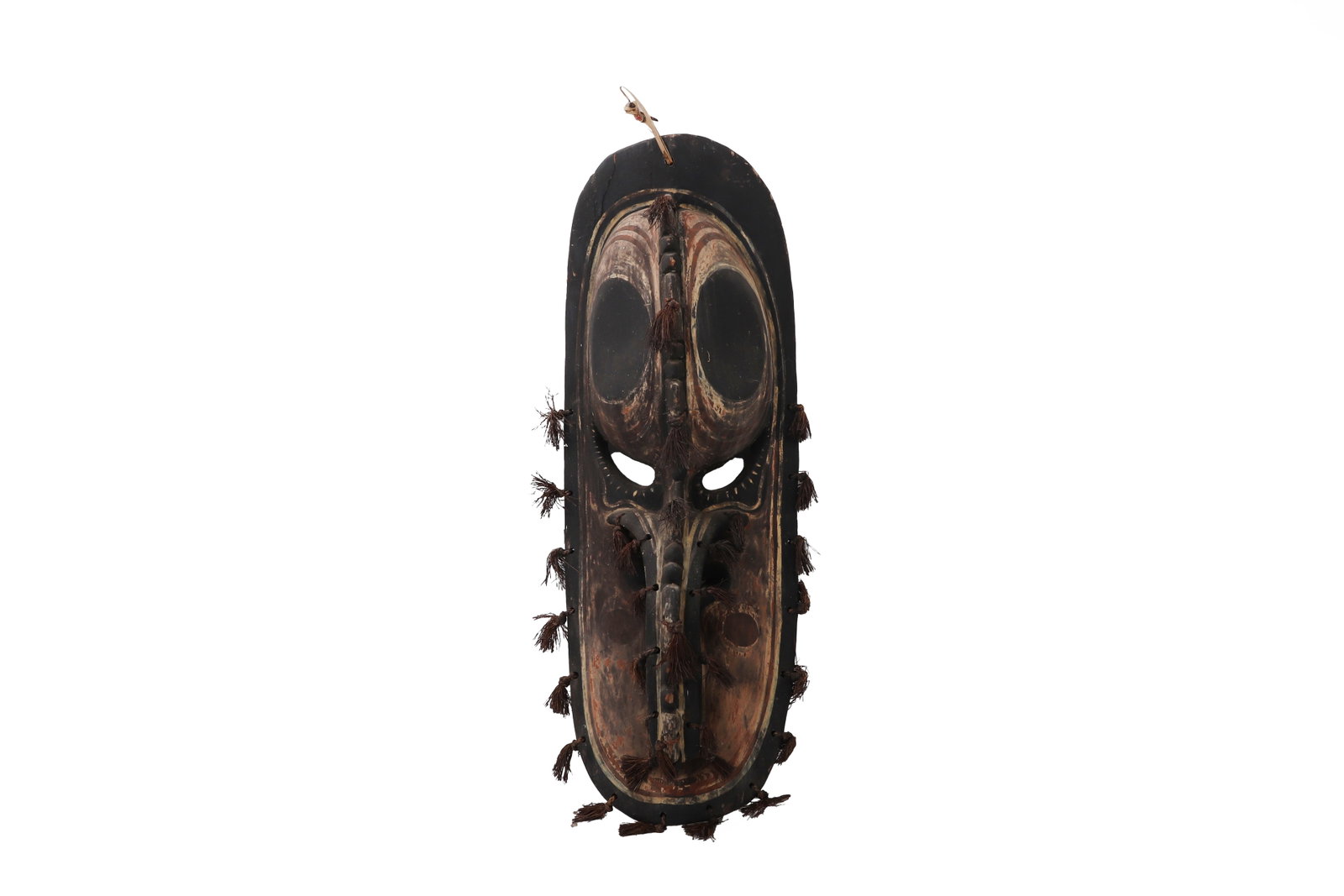 Ceremonial Papua New Guinea Mask: Papua New Guinea, Sepik River Region 20th Century Carved wooden mask of elongated oval form, the surface richly patinated and articulated with incised detailing and applied elements. The composition