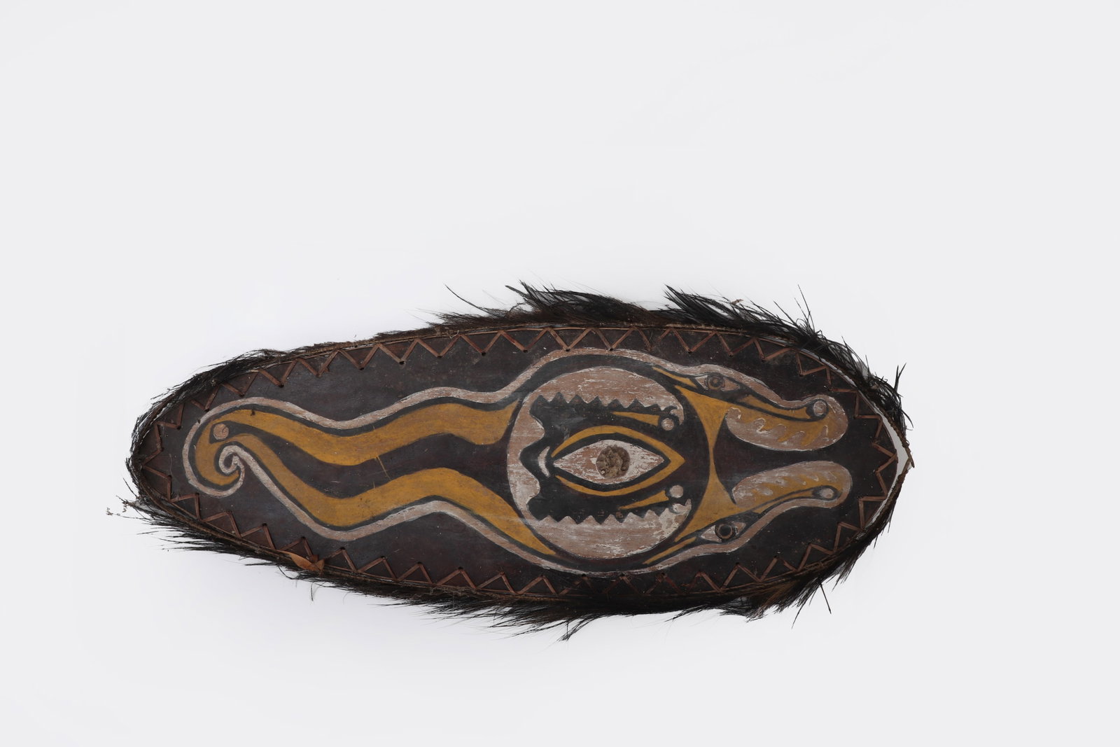 Sepik River Painted Gope Board, Papua New Guinea: Papua New Guinea, Sepik River Region 20th Century A carved wooden ceremonial board of elongated oval form, the surface painted with a bold, stylized composition centered on a large eye motif flanked