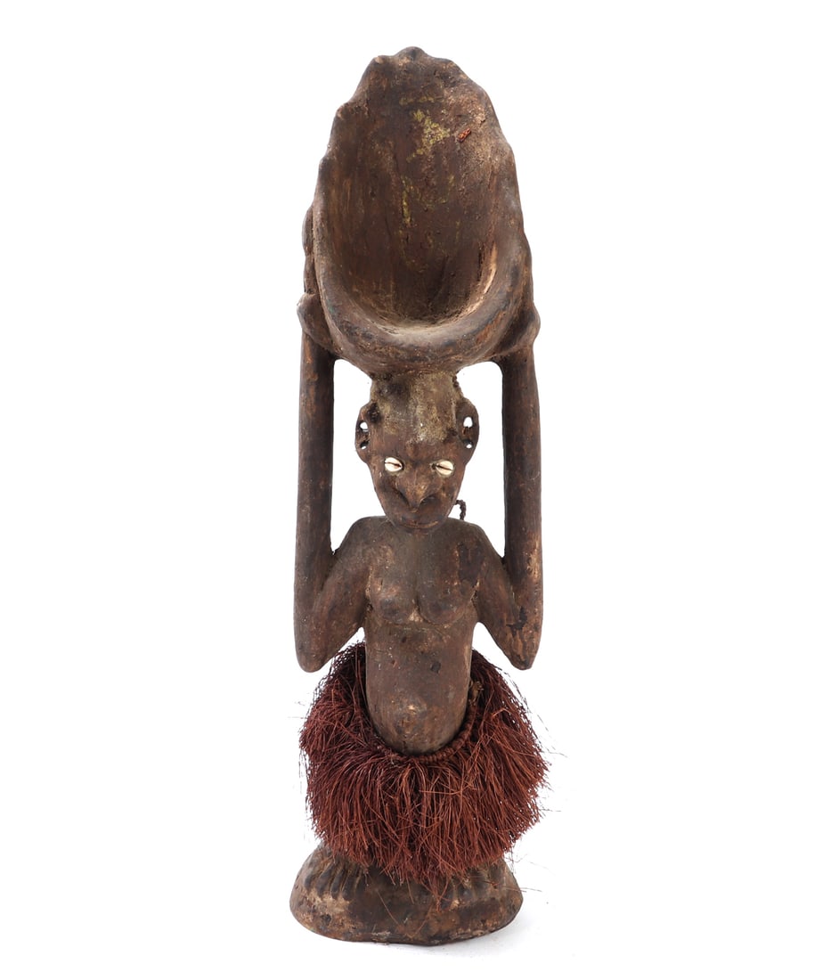 Papua New Guinea Wood Female Pigment Scoop: Papua New Guinea wood female pigment scoop. Carved from a single piece of hardwood, the figure highlights traditional craftsmanship with intricate details and natural patina. The standing female