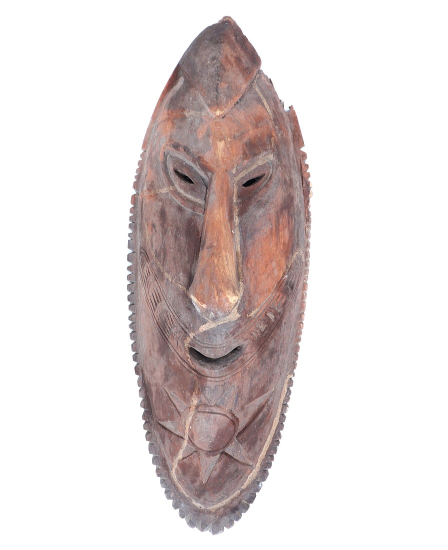 Handsome PNG Wood Carved Mask: Nicely carved wood PNG mask with almond slit eyes, grinning mouth with a star in high relief below his chin. Oval in shape with a hallowed out interior for the wearer. Size 20" L Collected prior to