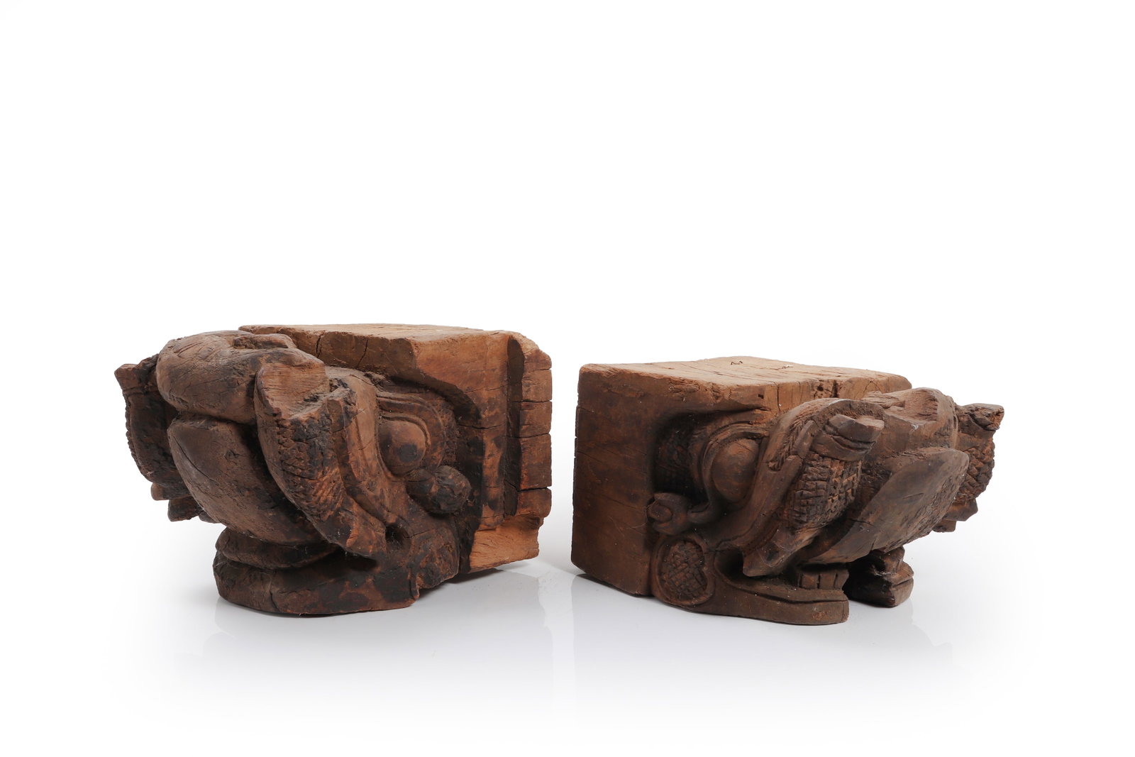 Pair of North Indian Carved Wooden Temple Corbels: India, Likely North India 19th to Early 20th Century A pair of carved wooden architectural corbels, each of substantial block form, adorned with projecting figural elements in high relief. The