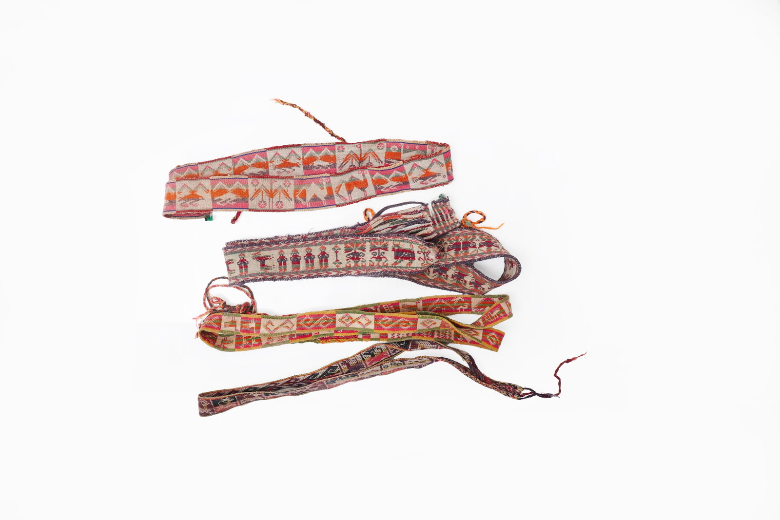 Group of Four Woven Textile Belts from Bolivia: Collection of four finely handwoven textile belts, each decorated with geometric and figural motifs in polychrome thread. The bands display a variety of traditional designs including stylized