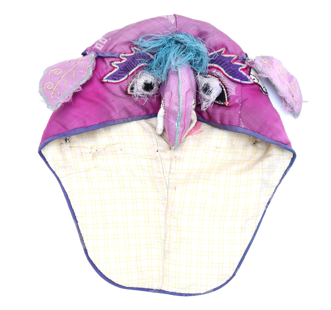 Chinese Child?s Elephant-Form Hat: China, late Qing dynasty to early Republic period. A child's embroidered textile hat in the form of an elephant, constructed with pink and magenta silk panels and a pale yellow checked cotton lining.