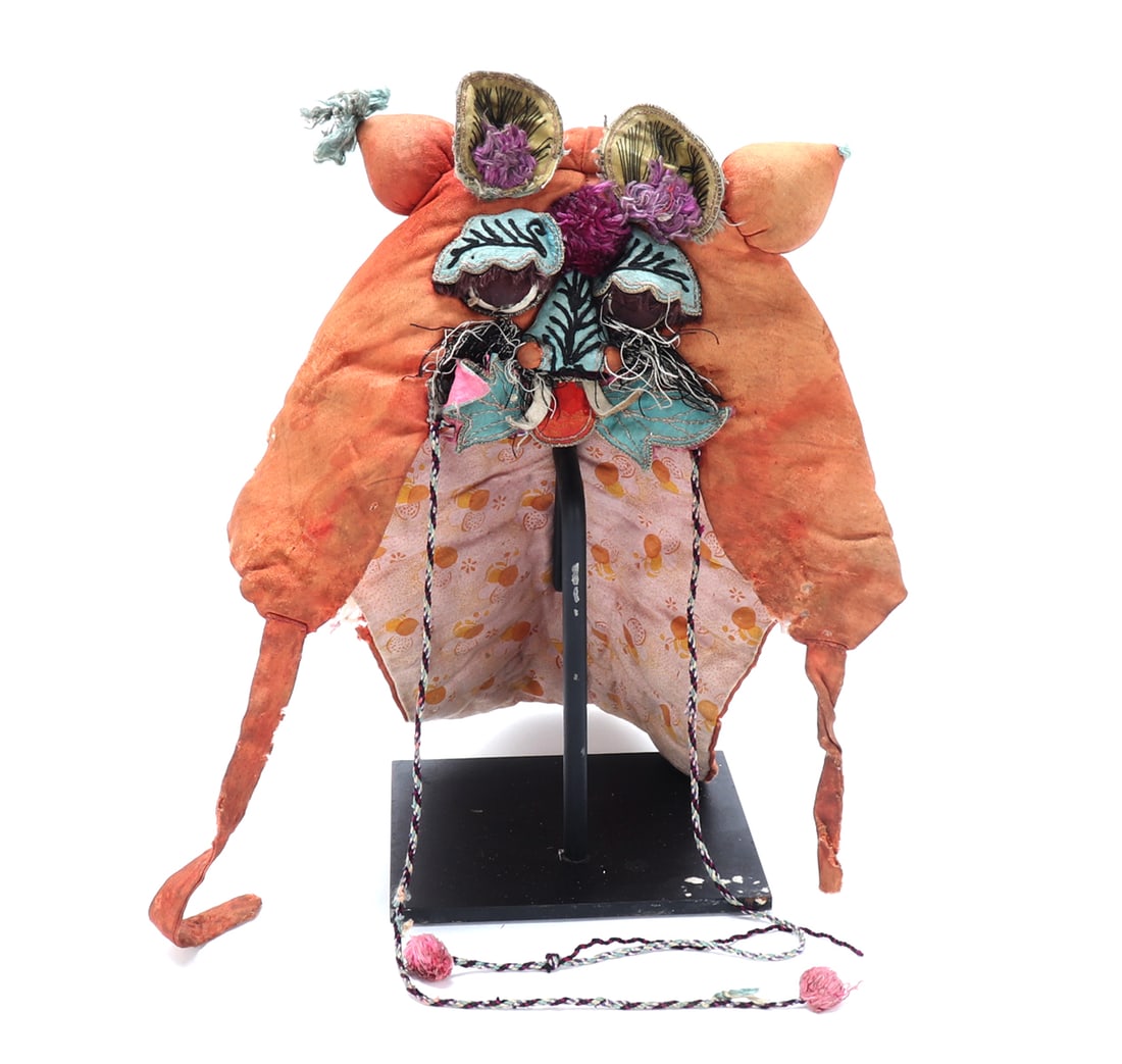 Chinese Child's Embroidered Silk Animal Hat: China, Qing dynasty or later. A child's embroidered silk animal-form hat, likely made in the form of a tiger or protective beast, constructed with orange silk panels and applied decorative elements. T
