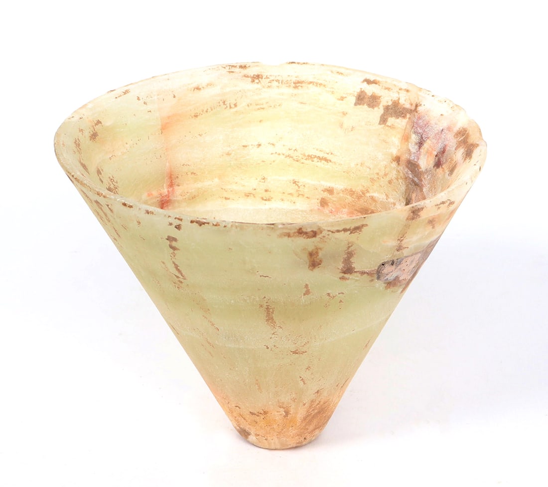 Conical Shaped Bactrian Cup: Circa 3000 BCE this conical shaped alabaster vessel unlike others has less marbling color throughout. The vessel is mainly almond white with red coloring to the edges and base. Size 3 1/2" H x 4 1/2"