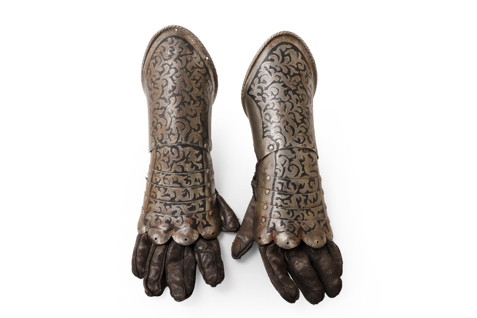 European Etched Steel Armor Gauntlets with Leather Gloves, 19th-20th C.: Continental Europe, likely 19th or 20th century. Pair of steel armor gauntlets with attached leather gloves. The gauntlets have rounded cuffs, layered wrist plates, scalloped lower edges, riveted
