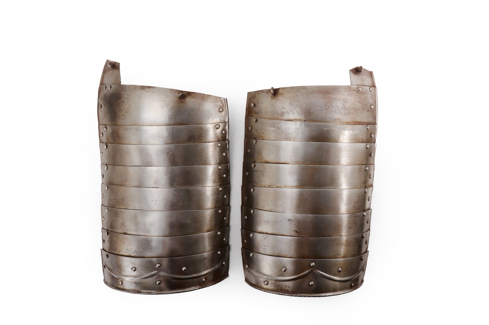 European Steel Tassets, Early 17th C. Style: Europe, early 17th century style. Pair of articulated steel tassets, each formed of overlapping horizontal lames with riveted construction, rounded lower terminals, embossed and roped or twisted