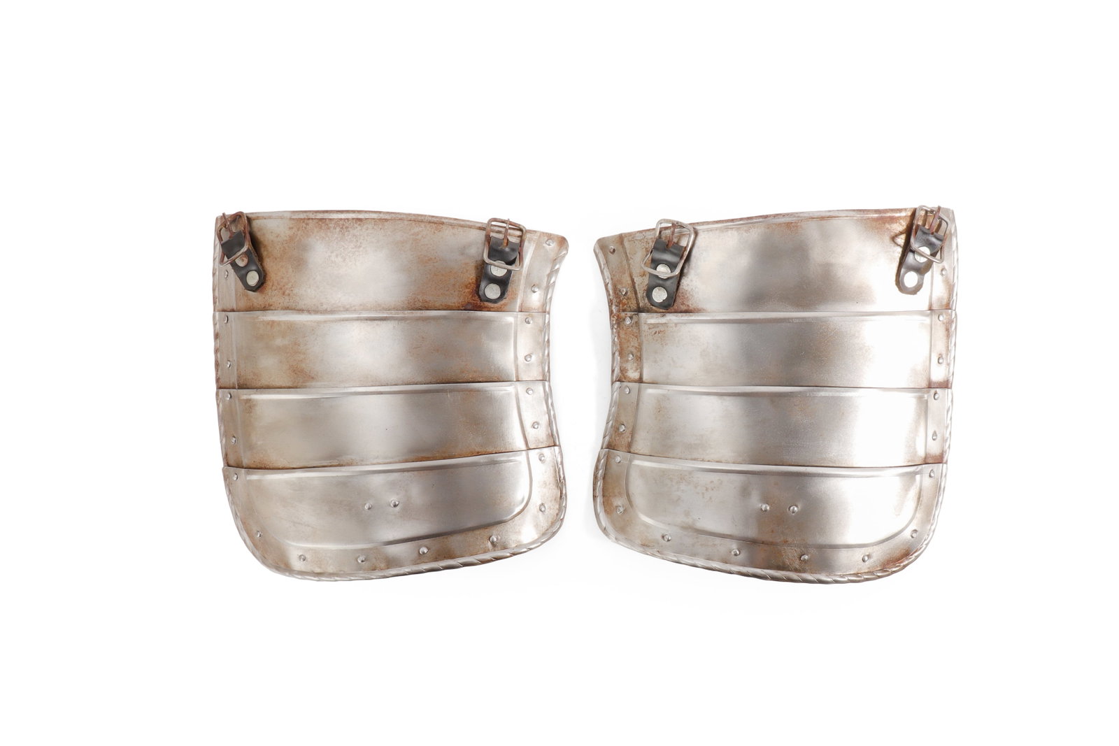 European Steel Tassets, 16th C. Style: European, in the 16th century style. Pair of steel tassets, each formed with four articulated horizontal lames, riveted side plates, leather suspension straps, and small buckle fittings. The lower