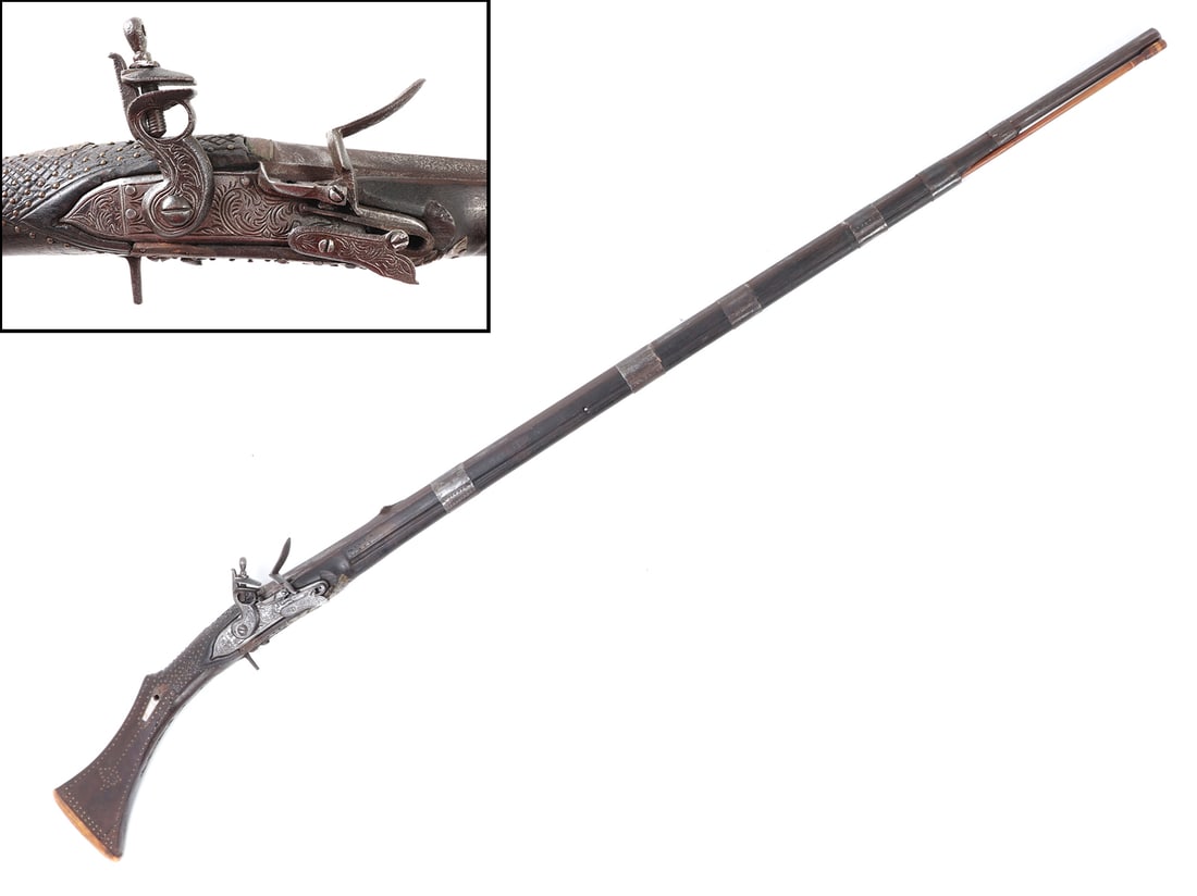 Large Islamic Flintlock Rifle: Large Islamic flintlock rifle with a checkered and brass stimpled wooden stock. Bone butt. Lock with incised floral designs. Octagonal barrel secured with 6 straps down the length. Size 58 5/8" L,