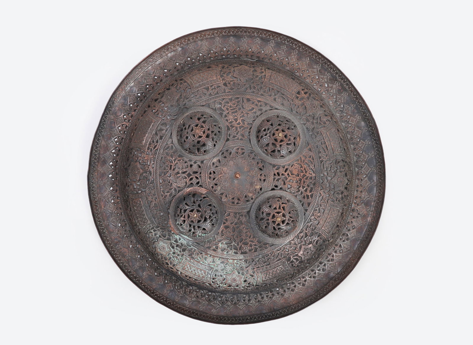 Gujarat Indian Copper Dhal, 19th C.: Indian dhal shield, Gujarat, 19th century. Circular convex copper alloy shield with finely pierced openwork decoration, chased floral and geometric designs, four domed bosses, and a textured grip