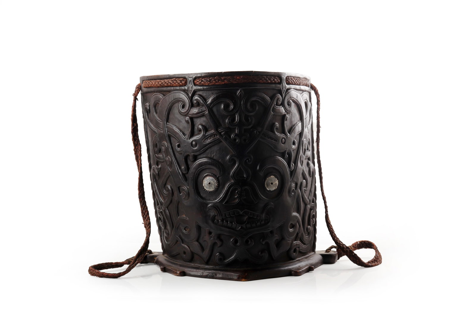 Dayak Carved Wood Baby Carrier, 19th C.: Borneo, Dayak peoples, 19th century. A carved wooden baby carrier of curved rectangular form, deeply worked on the exterior with scrolling foliate and abstract motifs centering a mask-like face with