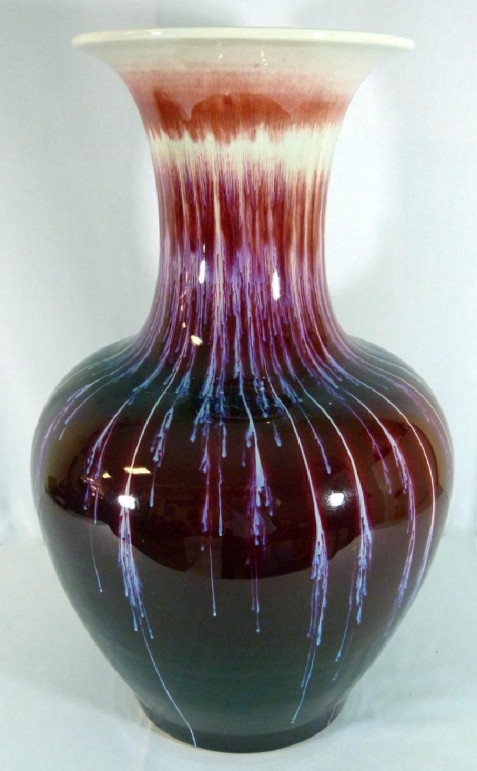 LARGE CHINESE FLAMBE OXBLOOD PORCELAIN VASE: Large Chinese flambe ox blood sang de boeuf glazed porcelain vase. Measures 25" (63cm) height by 14" (36cm) width.