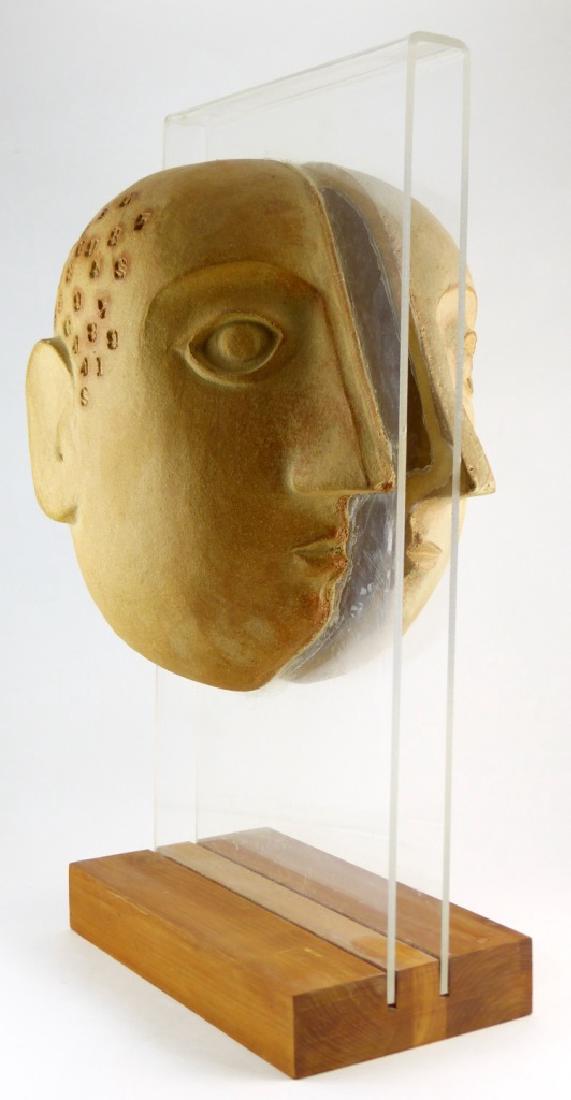 BENNINGTON POTTERY DAVID GIL TWO-SIDED SCULPTURE: Mid-century David Gil for Bennington Potters art pottery sculpture in the form of a split head with numbers mounted to lucite on wooden base. Impressed to inside of right side of head. Overall measure