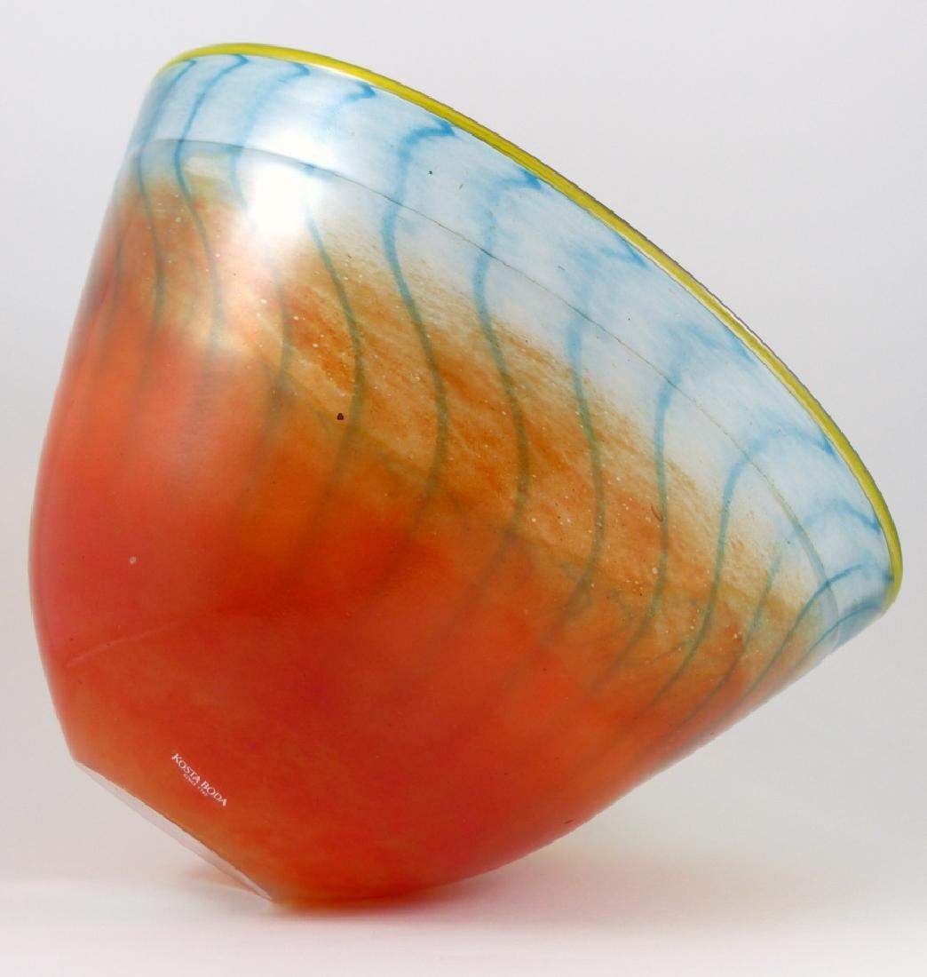 KJELL ENGMAN FOR KOSTA BODA ART GLASS BOWL: Kjell Engman for Kosa Boda art glass bowl, orange with blue stripes and yellow rim. Signed and numbered 59062 to underside. Holds original label to side. Measures 10 3/4" (27.5cm) diameter.