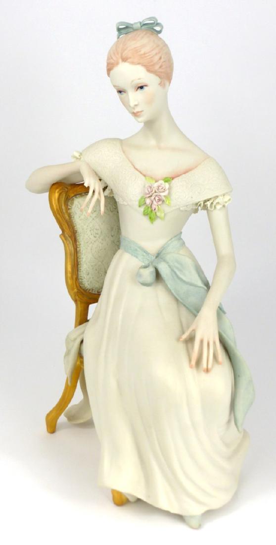 CYBIS PORCELAIN GIRL SEATED IN CHAIR FIGURINE: Cybis porcelain figure of a girl seated in chair. Marked to underside and numbered 476. Measures 12" (30.5cm) height.