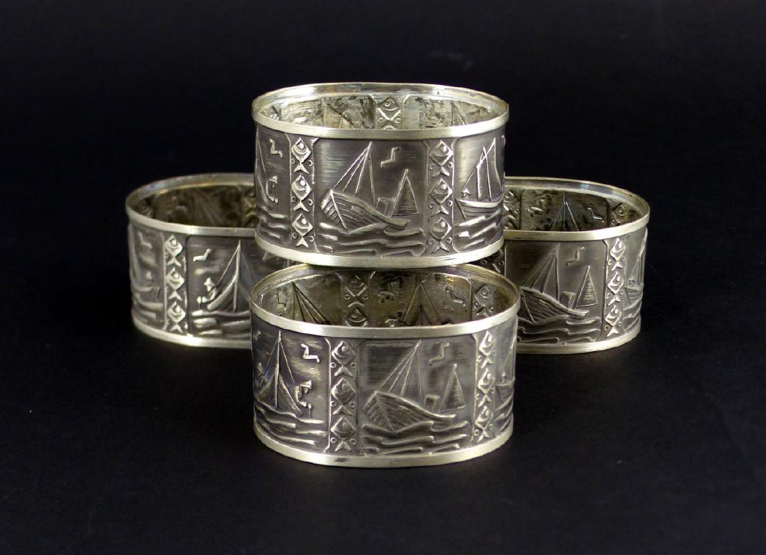 4pc NAUTICAL NAPKIN RINGS: 4 white metal Napkin rings having a nautical theme with fish, boats and fisherman. Each measures 2" (5cm) width.