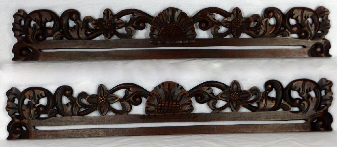 PR INDONESIAN CARVED WOOD TAPESTRY HANGERS: Pair of Indonesian carved wood tapestry or textile hanging bars. Each having a floral motif measures 27 1/2" (69.8cm) length.