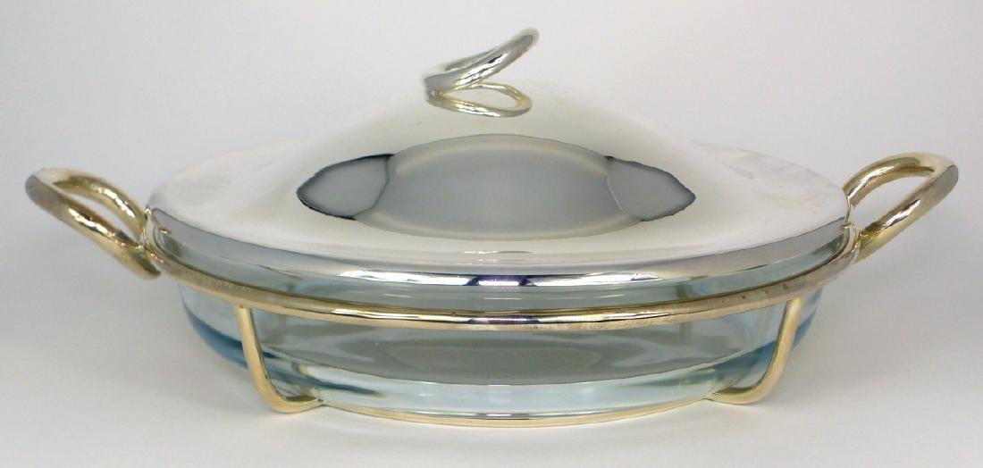 CHRISTOFLE SILVER PLATED 'VERTIGO' BAKING DISH: Christofle silverplated and glass round covered casserole / baking dish in the Vertigo pattern. Marked near edge of lid. Measures 14 1/4" (36cm) width.