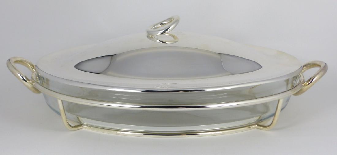 CHRISTOFLE SILVER PLATED VERTIGO OVAL BAKING DISH: Christofle silverplated and glass oval covered casserole / baking dish in the Vertigo pattern. Marked near edge of lid. Measures 17" (43cm) length.