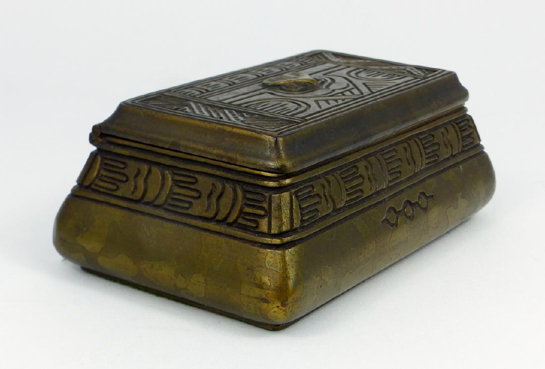 TIFFANY STUDIOS 'AMERICAN INDIAN' BRONZE STAMP BOX: Tiffany Studios bronze stamp box in the 'American Indian' pattern. Marked Tiffany Studios, New York and numbered 1184 to underside. Measures 5" (12.7cm) length.