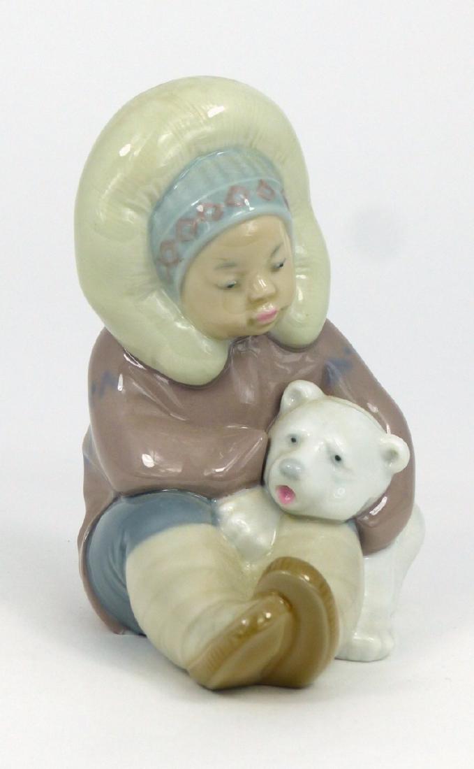 LLADRO ESKIMO CHILD w POLAR BEAR PORCELAIN FIGURE: Lladro porcelain figure of an eskimo child playing with polar bear cub #1195. Marked to underside. Measures 4 5/8" (11.8cm) height.