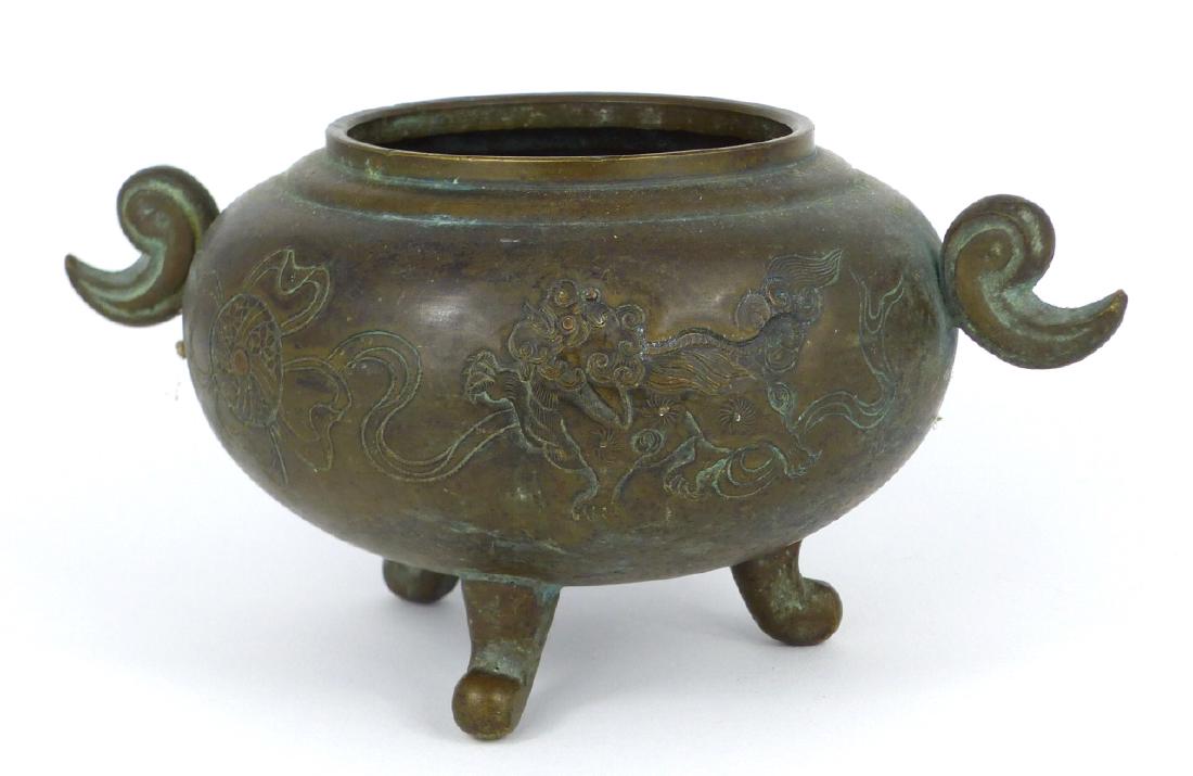 CHINESE BRONZE HANDLED TRIPOD CENSER: Chinese bronze handled tripod censer with Qilin decoration. Measures 6 1/2" (16.5cm) width.