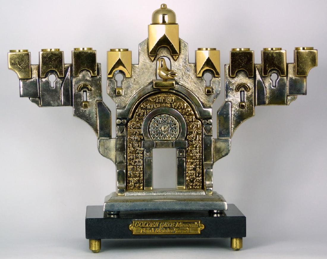 FRANK MEISLER 'GOLDEN GATE MENORAH' SCULPTURE: Frank Meisler Judaica metal sculpture on marble base, titled 'Golden Gate Menorah'. Features a Hanukkah Menorah in silver and gilded tones made to look as a structure, above an Oriental dome with Hebr