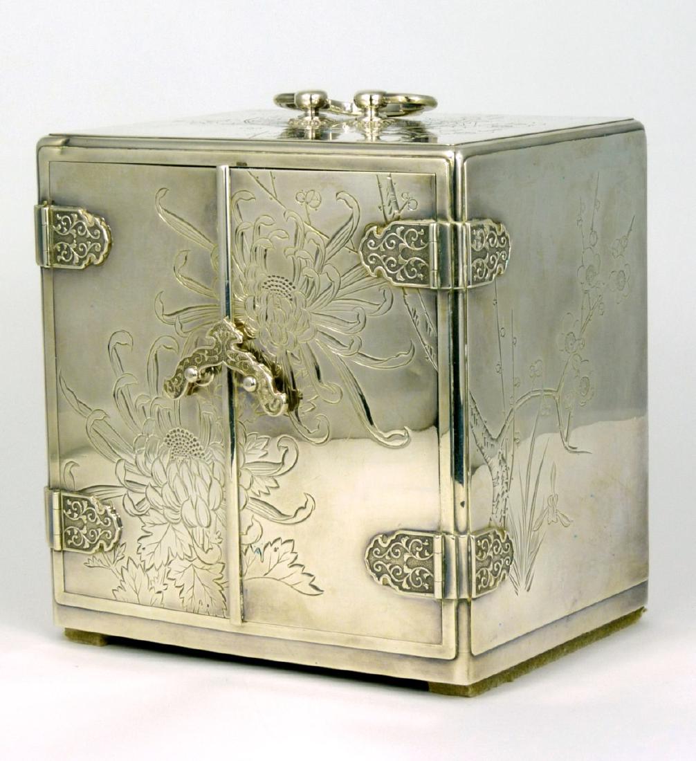 JAPANESE STERLING SILVER JEWELRY BOX: Japanese sterling silver jewelry box decorated with floral blossoms. Two doors open to reveal three black lacquered drawers, each felt lined. Measures 5 1/8" (13cm) height and width.