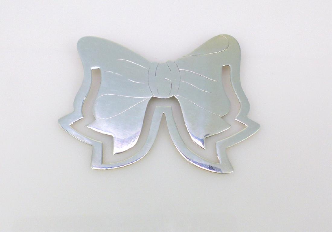 TIFFANY & CO STERLING SILVER 'BOW' BOOKMARK: Tiffany & Company sterling silver bookmark in the form of a bow. Marked Tiffany & Co, 925. Measures 2 1/8" (5.4cm) width.