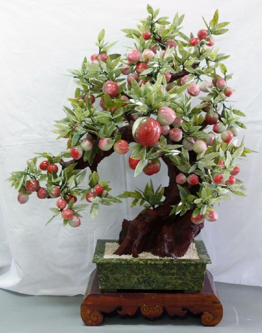MONUMENTAL CHINESE HARDSTONE PEACH TREE: Monumental Chinese hardstone and glass peach tree in rectangular green hardstone planter. Measures 41" (104cm) width x 44" (111.7cm) height + 5 3/4" (14.5cm) wooden stand.
