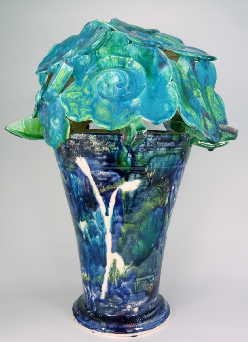 ROBERT BEAU KVENILD CERAMIC BOUQUET SCULPTURE: Robert 'Beau' Kvenild (American) contemporary ceramic sculpture in the form of a flower pot having blues, greens and purples throughout. Signed to underside. Measures 16 1/2" (41.8cm) height.