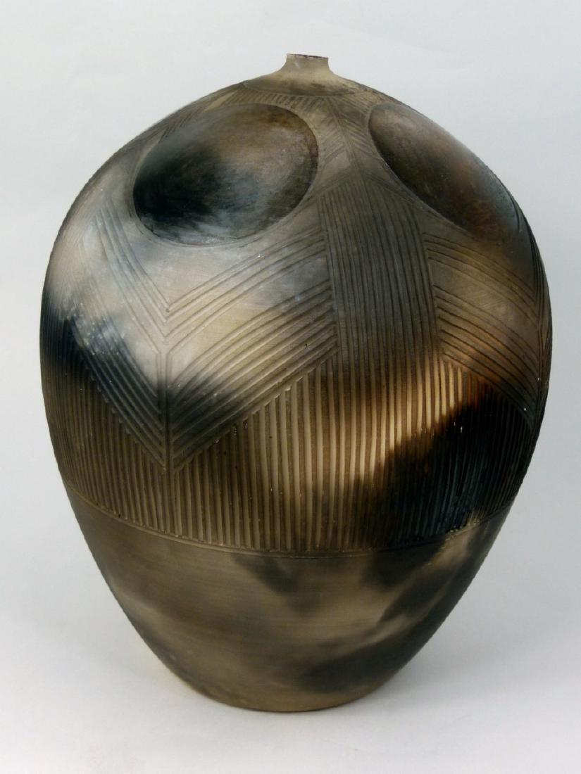 NANCEE MEEKER STUDIO ART POTTERY BOTTLE VASE: Nancee Meeker pit fired ceramic vase from her Geometric Series. Thrown earthenware, etched, stone burnished and smoked in exotic hardwood sawdust. Signed to underside. Measures 10" (25.4cm) height.