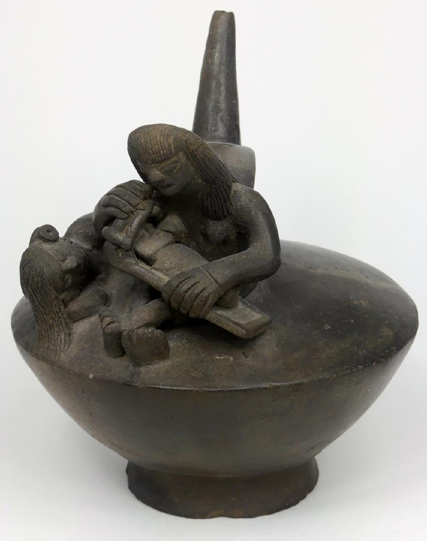 PRE-COLUMBIAN FIGURAL BLACKWARE VESSEL: Pre-Columbian blackware vessel having handle and single spout. One figure is seated holding child with another figure reclining to side. Measures 7 1/2" (19cm) height x 6 1/2" (16.5cm) diameter.