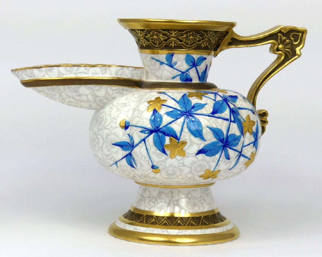 ANTIQUE ROYAL WORCESTER PORCELAIN PITCHER: Royal Worcester porcelain pitcher with blue and gilt foliage. Marked to underside. Initial PE. Circa 1883. Measures 7 1/2" (19cm) length x 5 1/2" (14cm) height.