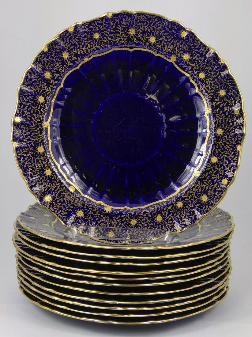 12pc MINTONS GILT COBALT PORCELAIN DINNER PLATES: Set of 12 Minton gilt cobalt blue porcelain dinner plates. Each decorated with elaborate floral and tendril gilt pattern over cobalt border. Each holds Mintons globe mark to underside. Retailed by The