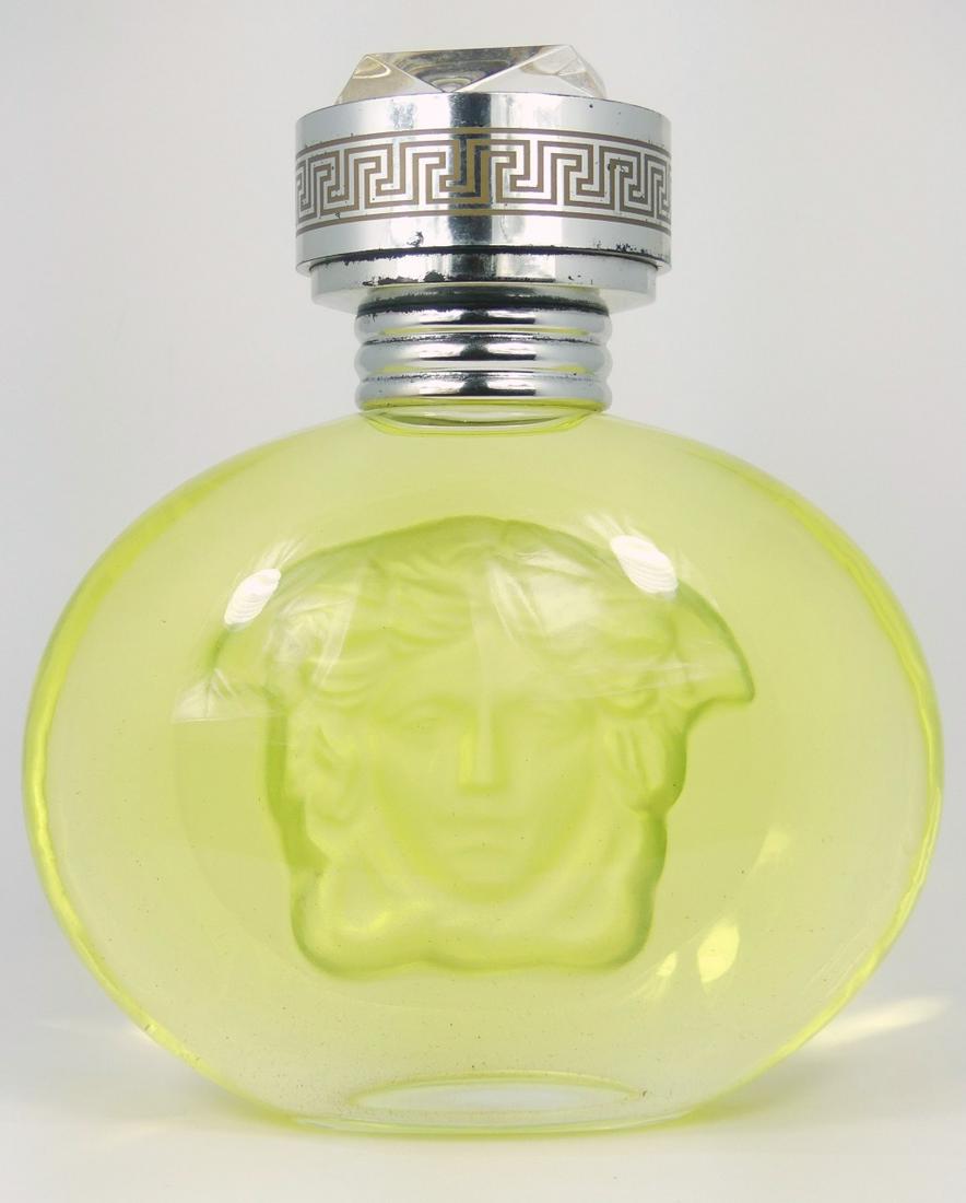 GIANNI VERSACE BLONDE FACTICE PERFUME BOTTLE: Gianni Versace 'Blonde' glass factice perfume bottle. Designed with deeply impressed and frosted Versace Medusa head logo to center. Measures 11" height.
