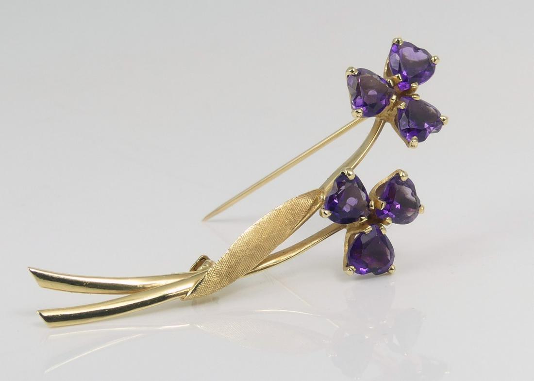 14kt YELLOW GOLD & AMETHYST BROOCH: 14kt yellow gold brooch in the form of two flowers with six heart-cut amethyst stones. Marked 14K. Stones measure approx 6mm width. Measures 2 1/8" overall length. Total weight 3.4dwt.