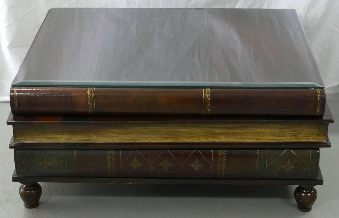 MAITLAND-SMITH FAUX BOOK COCKTAIL TABLE w DRAWERS: Maitland Smith coffee table in the form of a stack of books. Each book's binding opening as a drawer. Includes custom fitted beveled glass top. Holds brass Maitland-Smith plaque inside top drawer. Mea