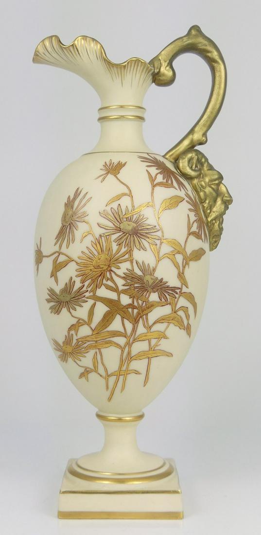 ROYAL WORCESTER GILT PORCELAIN PITCHER: Royal Worcester porcelain pitcher with mask handle. Gilt accents and floral decoration. Marked to underside. Measures 10" height.