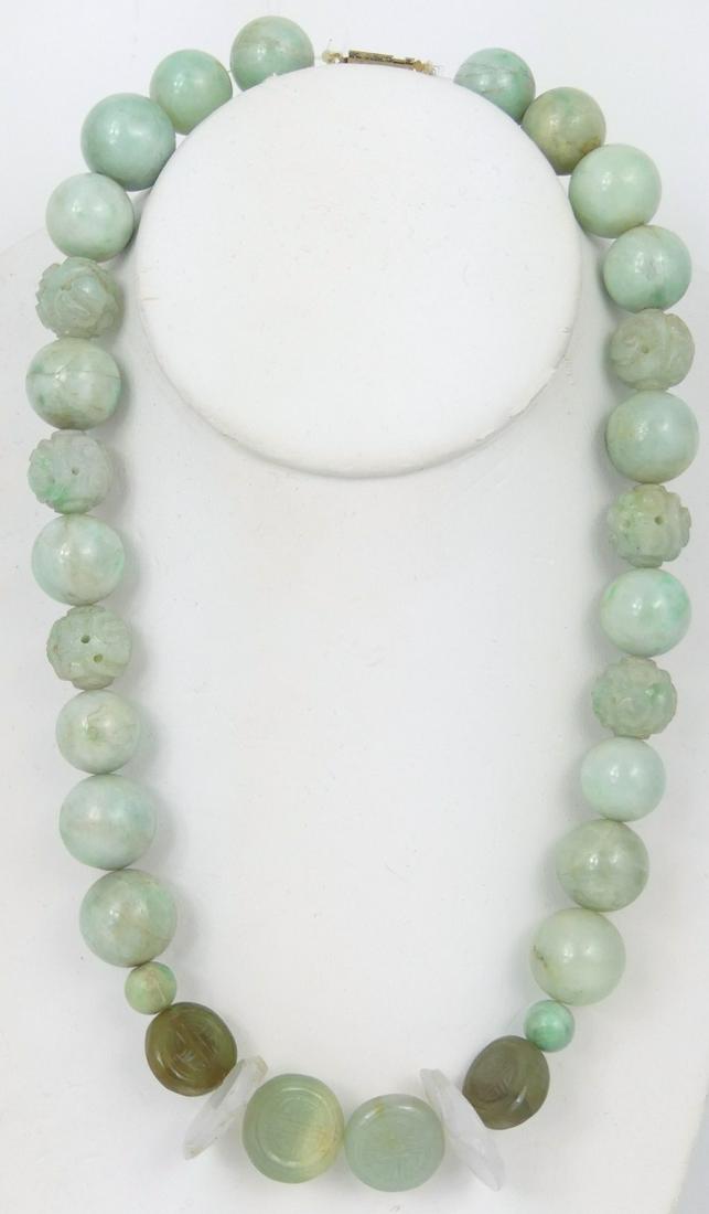 CHINESE JADEITE BEADED NECKLACE: Chinese jadeite jade beaded necklace. Round, carved and disc-form beads. Largest round beads measure 17mm diameter. Necklace measures 18" length.