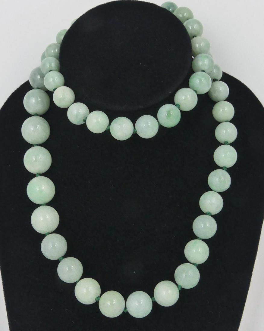 CHINESE JADEITE GRADUATED BEAD NECKLACE: Chinese jadeite beaded necklace of graduating design. Largest bead measures 17mm. Smaller beads measures 12mm. Measures 30" (76cm) length.