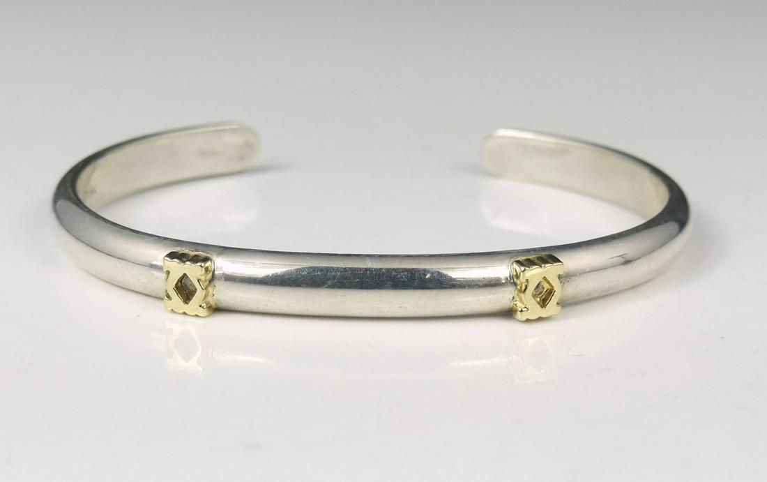 CARTIER STERLING SILVER 18kt YG DOUBLE C CUFF: Cartier sterling silver cuff bracelet with 18kt yellow gold Double C logo decoration. Marked Cartier, Sterling, 18K. Measures 2 5/8" diameter.