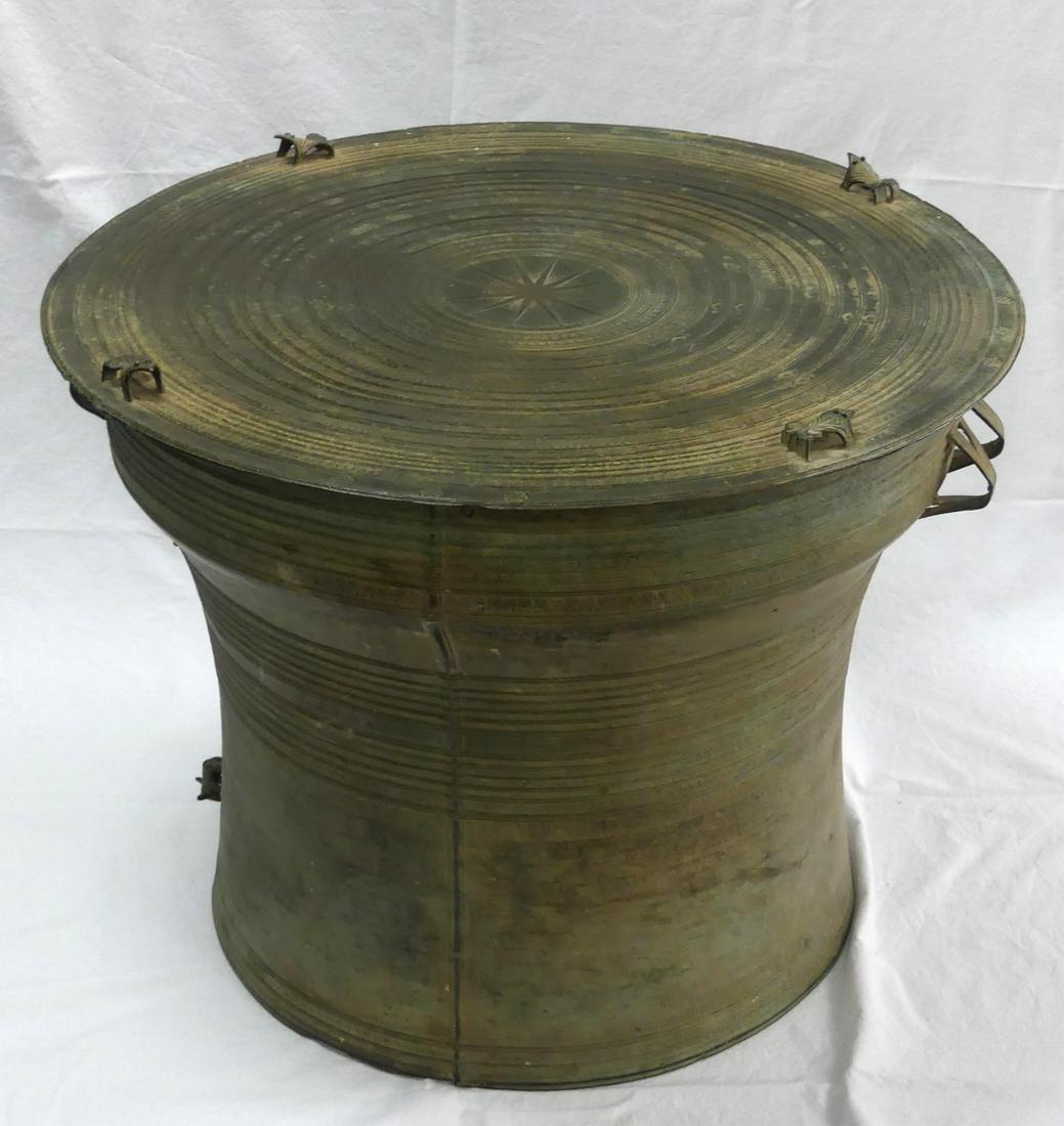 SOUTHEAST ASIAN BRONZE RAIN DRUM: Southeast Asian bronze frog kha rain drum. Circular top features star at the center with radiating decorative bands and four frog form finials. Body is flanked by strap handles and has bands of decora