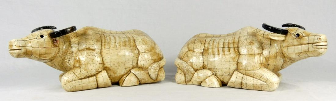 PR CHINESE OX BONE COW SCULPTURES: Pair of Chinese ox bone recumbent bulls. Each measures approx 12" length.