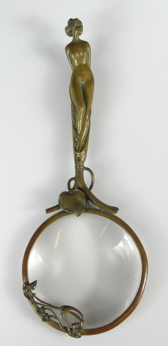 ART NOUVEAU BRONZE MAGNIFYING GLASS: Art Nouveau bronze magnifier with nude figural hande. Measures 7 3/4" length.