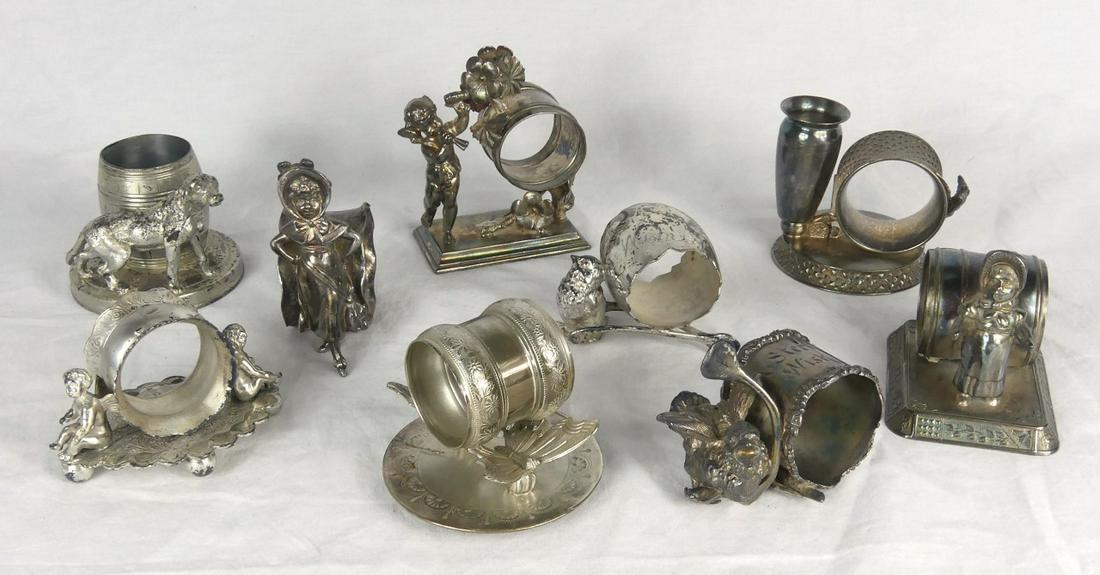9pc SILVER PLATED FIGURAL NAPKIN RING HOLDERS: 9 silverplate figural napkin ring holders. Includes cherubs, girls, birds, dog, butterflies, Various manufactuers. All but two are marked to underside. Largest measures 4" height.