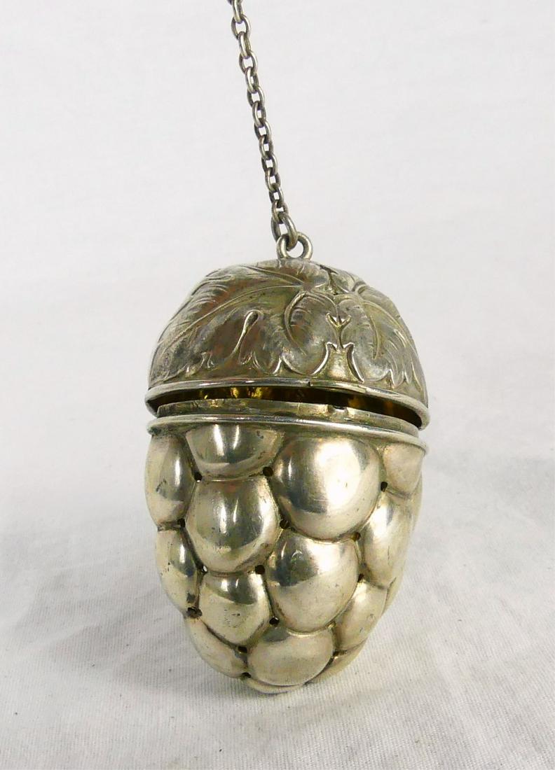 GERMAN 800 SILVER 'ACORN' TEA INFUSER: German 800 silver tea ball infuser / strainer in the form of an acorn. Hinged with vermeil interior. Marked 800 to hook. Measures 2 3/8" length excluding chain.