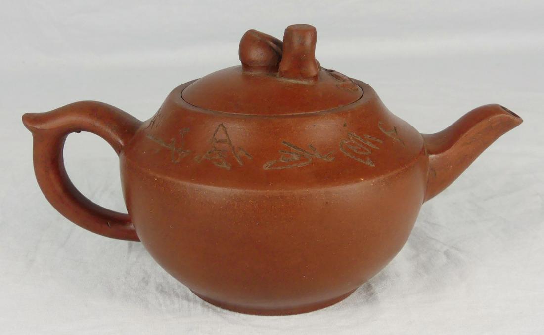 CHINESE YIXING ZISHA CLAY TEAPOT: Chinese Yixing Zisha clay teapot. Peach and branch handle to lid. Marked to underside. Measures 8" length.